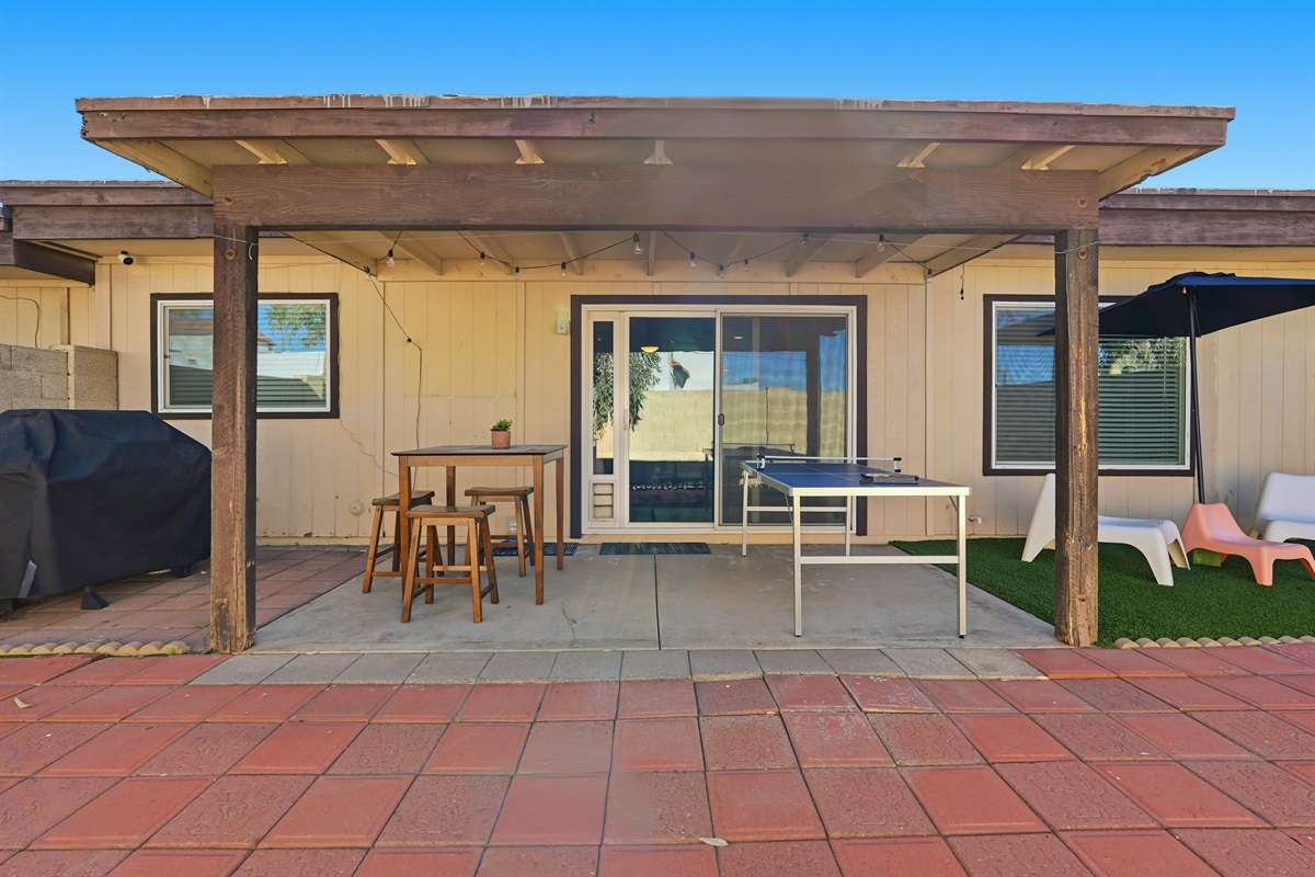 Relax under a shaded patio—string lights, games, and cozy outdoor moments await.