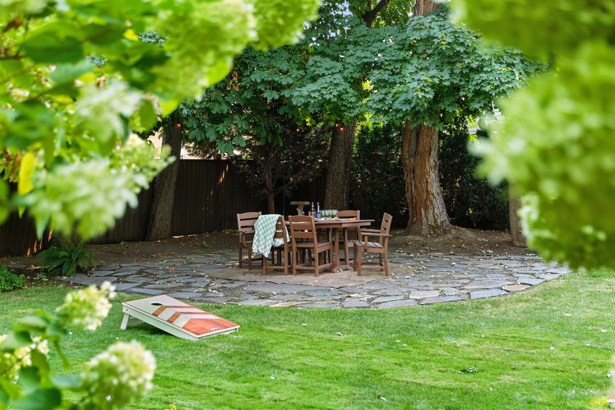 Large backyard with a park-like setting, outdoor dining for 6, corn hole, and 6 lounge chairs gathered around the propane fire table (propane provided)