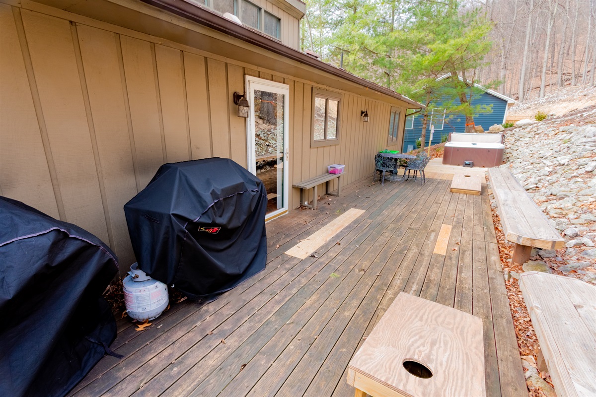 Back patio - 2 propane gas grills, cornhole boards, metal dining table and chairs, built-in benches, and hot tub. the front patio has 2 picnic tables,