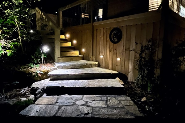 Landscape lighting for security line the stone and wooden steps.