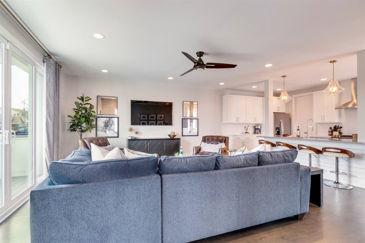 - Comfortable sectional seating with plenty of space to gather or watch smart TV - Open layout flows effortlessly from the living room to the chef’s kitchen - Large windows and modern lighting create a bright, welcoming atmosphere