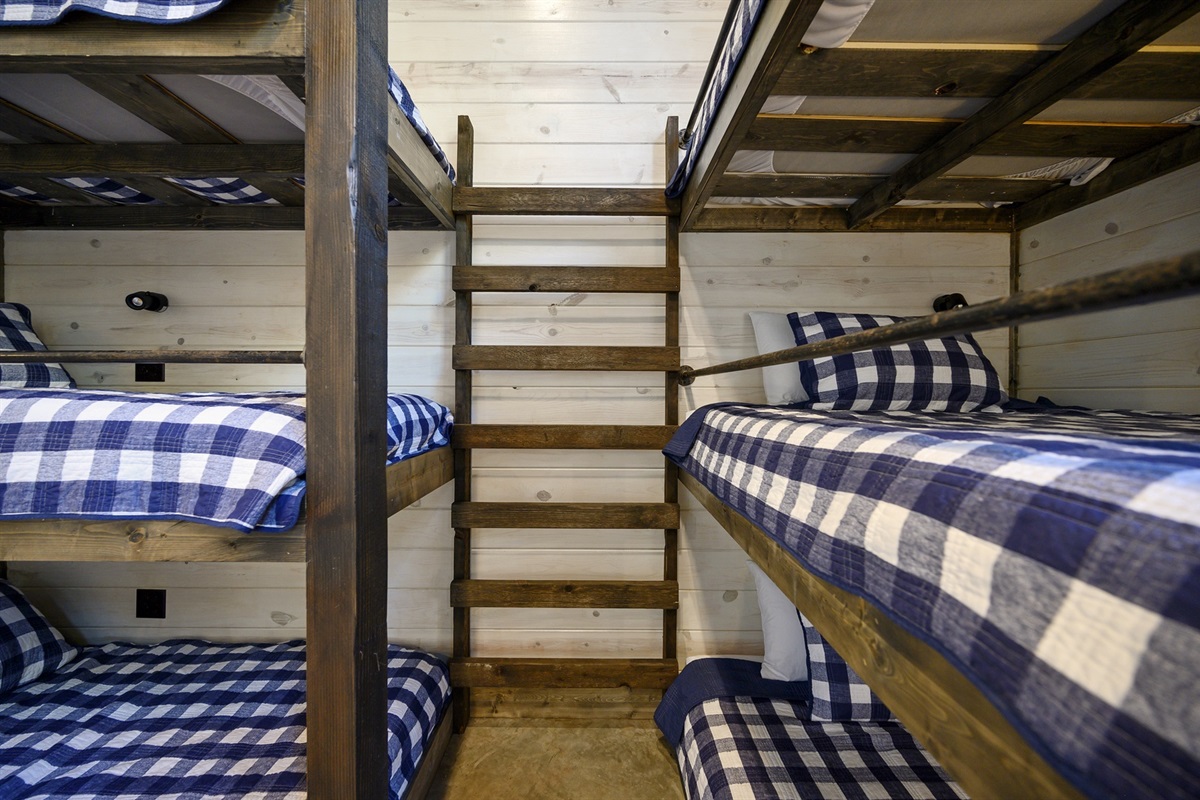 Crisp plaid bedding and custom-built bunks bring charm and comfort to this inviting shared space.