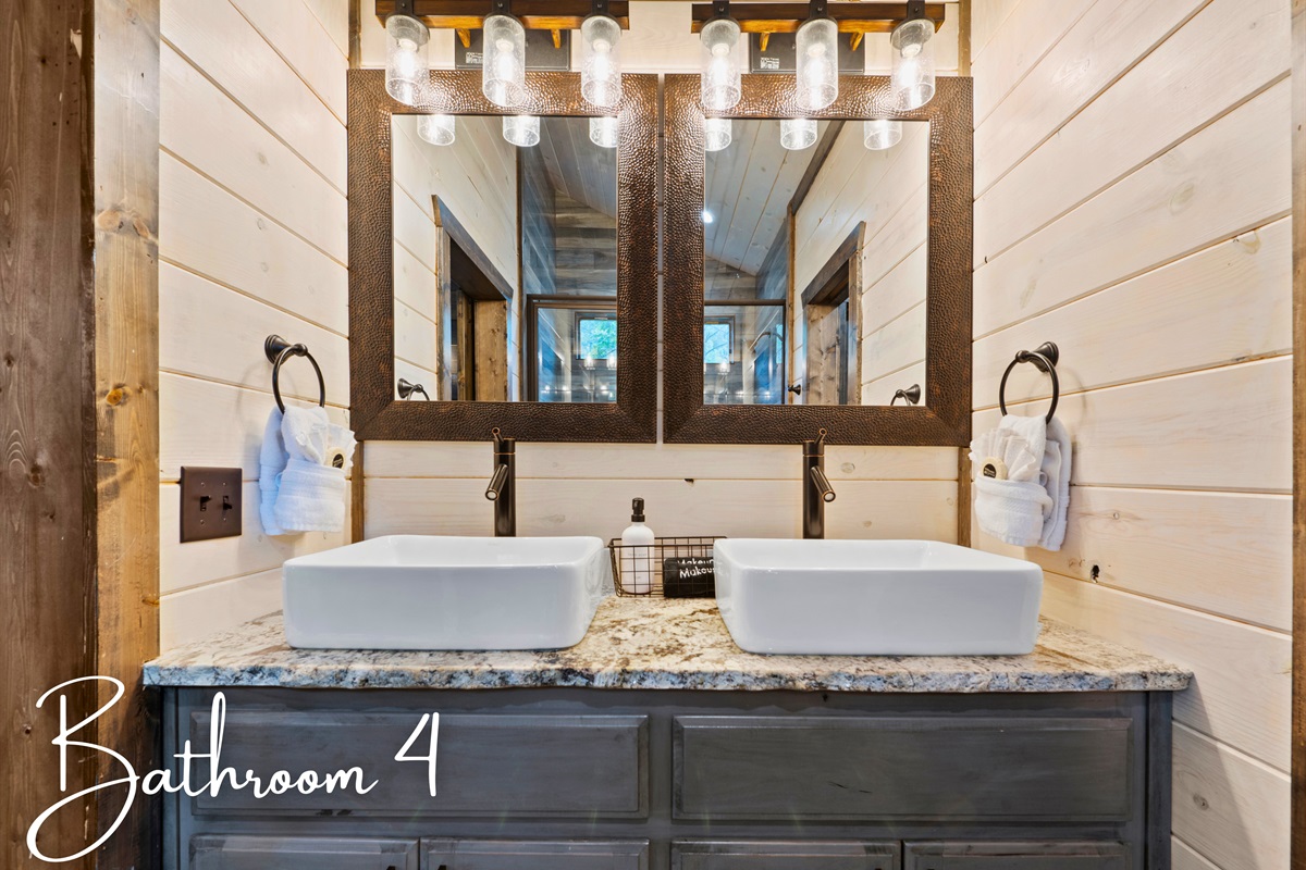 A modern bathroom with dual sinks, contemporary mirrors, and a glass-enclosed shower