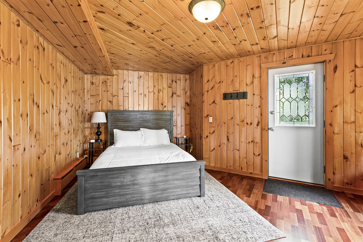 Relax in this peaceful basement king bedroom, perfectly located near the arcade room for easy fun while still offering plenty of privacy. Enjoy the walk-out access to the outdoors, nightstand charging ports large dresser and comfy chairs!