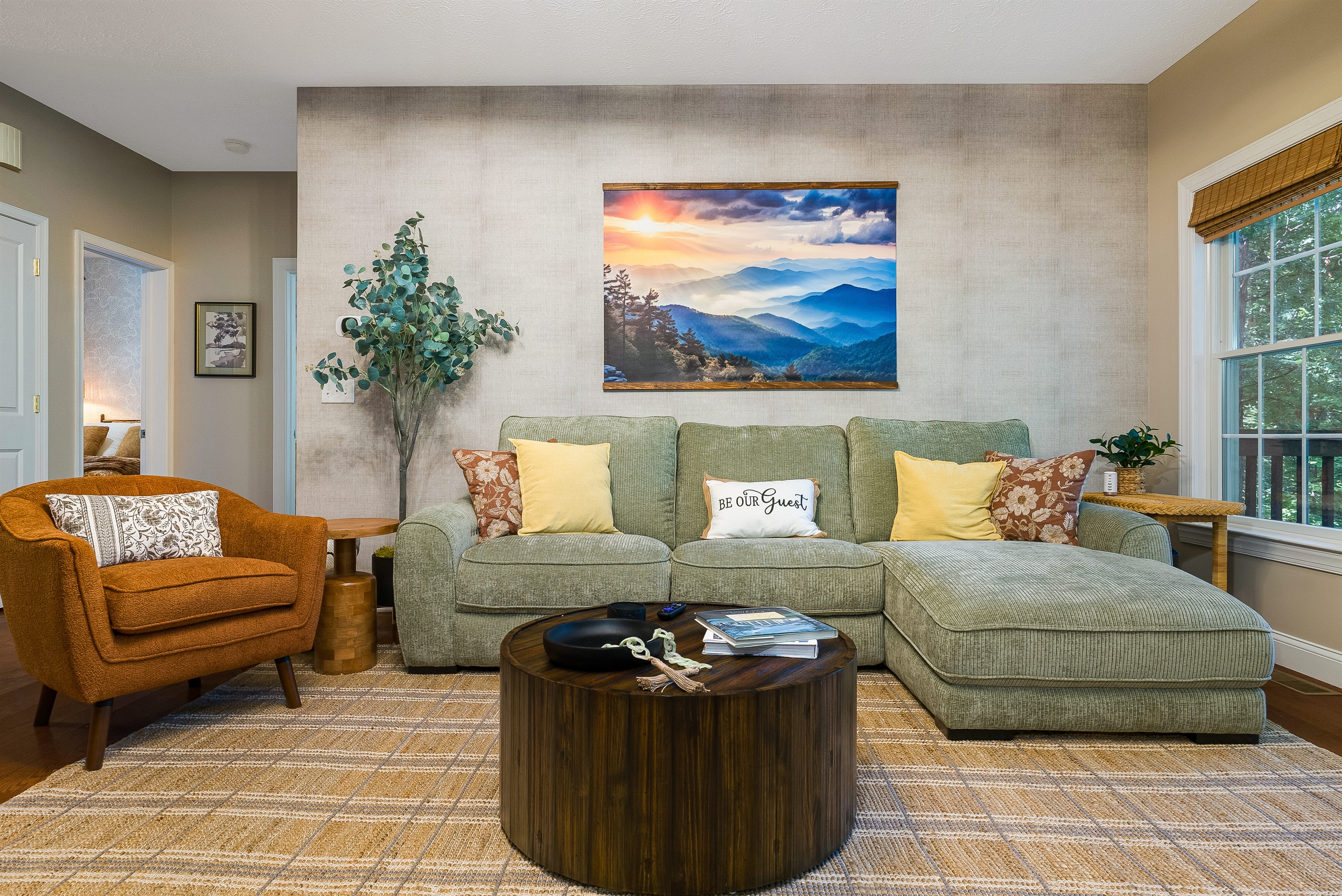 Stylish sectional with pops of color, cozy armchair, and mountain-inspired décor — the perfect spot to curl up with a book or movie.