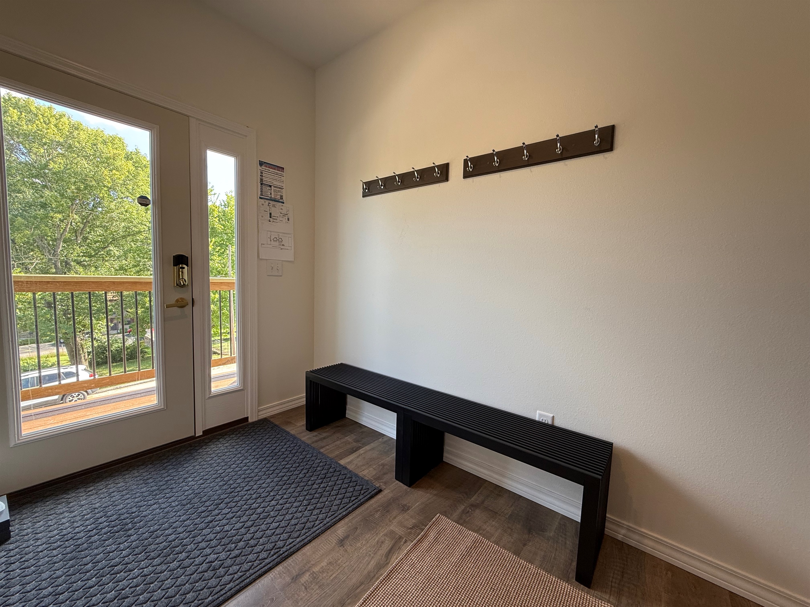 Seating for putting on shoes and coat hangers conveniently
 placed above 