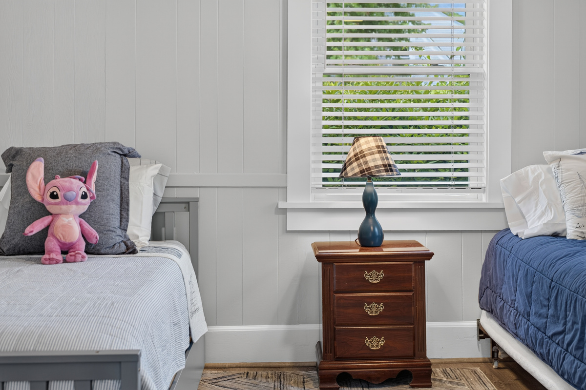 Bright twin bedroom offering a cozy and practical space for a restful stay.