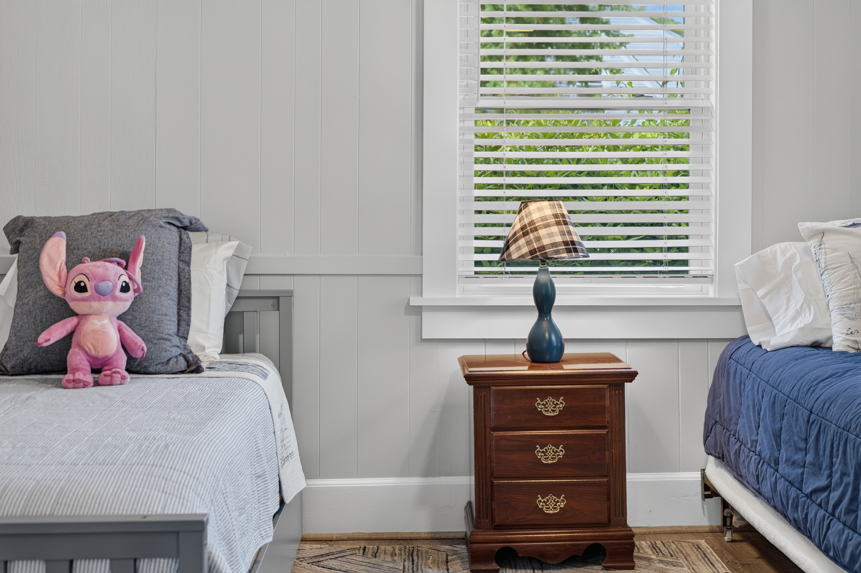 Bright twin bedroom offering a cozy and practical space for a restful stay.