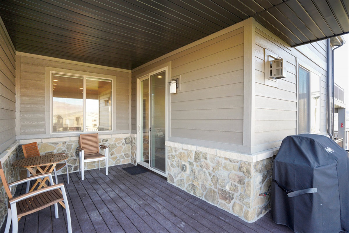 Private deck off the living room with grill and outdoor dining space.