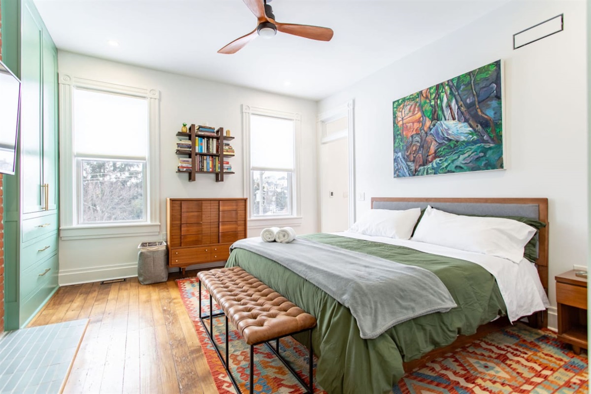 A spacious bedroom with large windows that let in plenty of natural light, complemented by classy furniture and minimalist décor, creating a sophisticated and serene atmosphere.