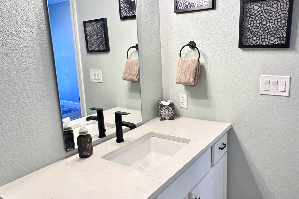 Bathroom 2 with an extended sink top and tub shower combo.