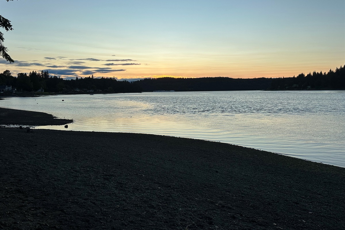 Golden hues paint the sky as the sun sets over Walker Park’s peaceful shoreline on Hammersley Inlet