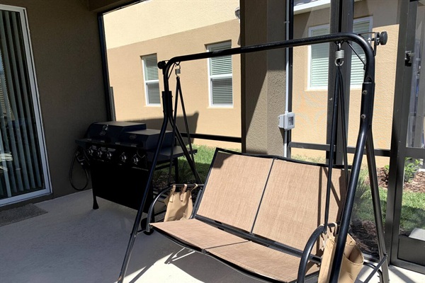 Outdoor swing in enclosed pool area. 
