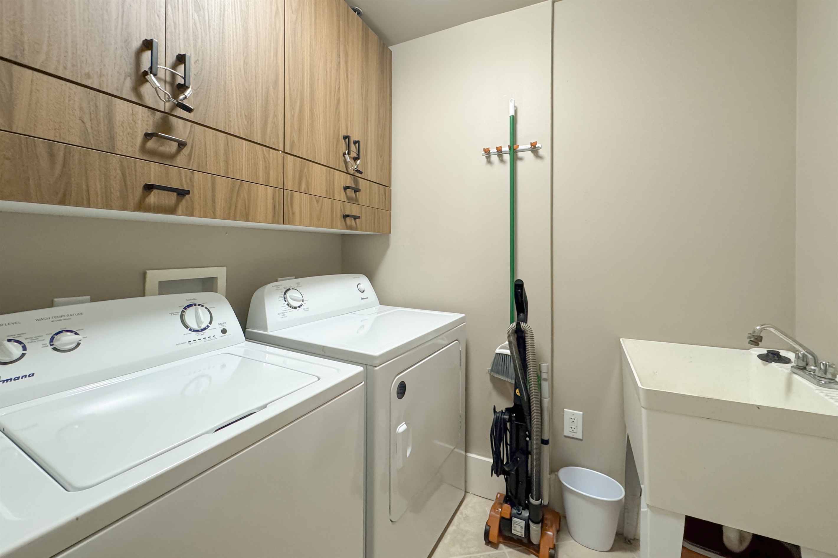 Maximize your comfort with this functional laundry area, featuring an in-unit washer/dryer and shelving for organized storage.