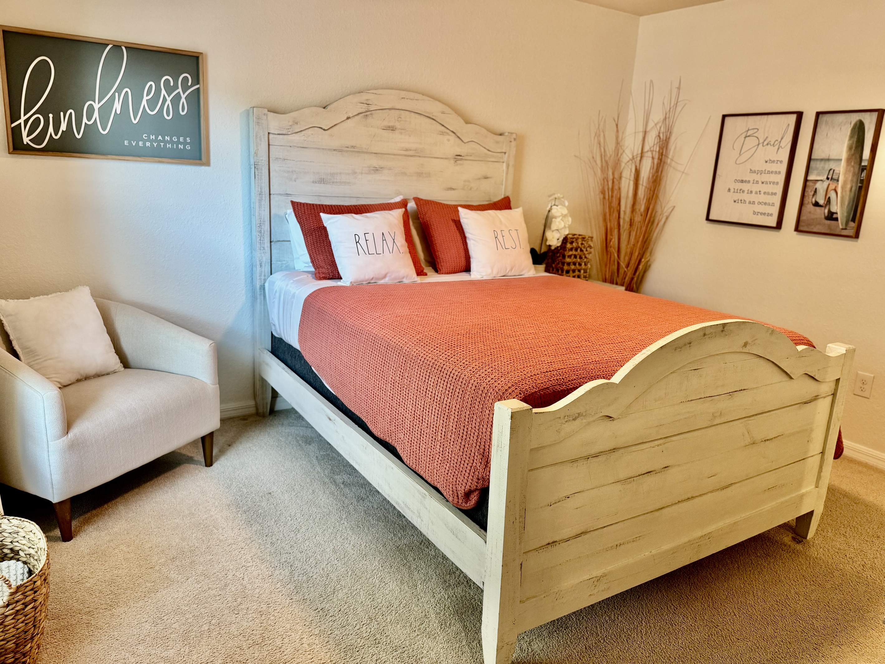 Second bedroom—queen bed, TV, accent chair.