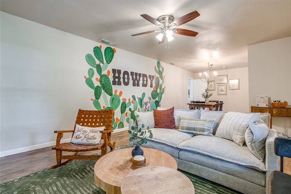 Living room with Howdy mural – Cowboy-themed lounge with comfy seating & fun Stephenville decor.
