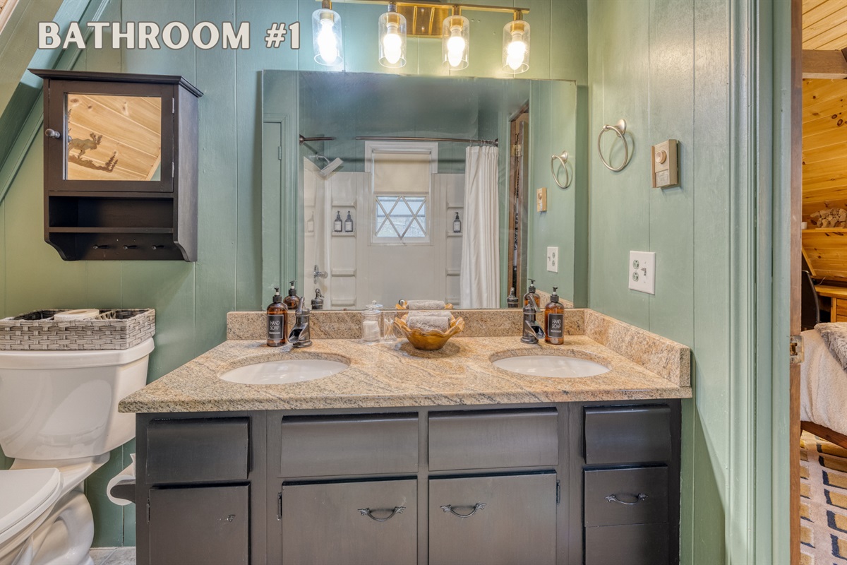 Bathroom #1 is an en-suite full bath with double sinks, granite countertop, large shower, and ample storage for a comfortable stay.  