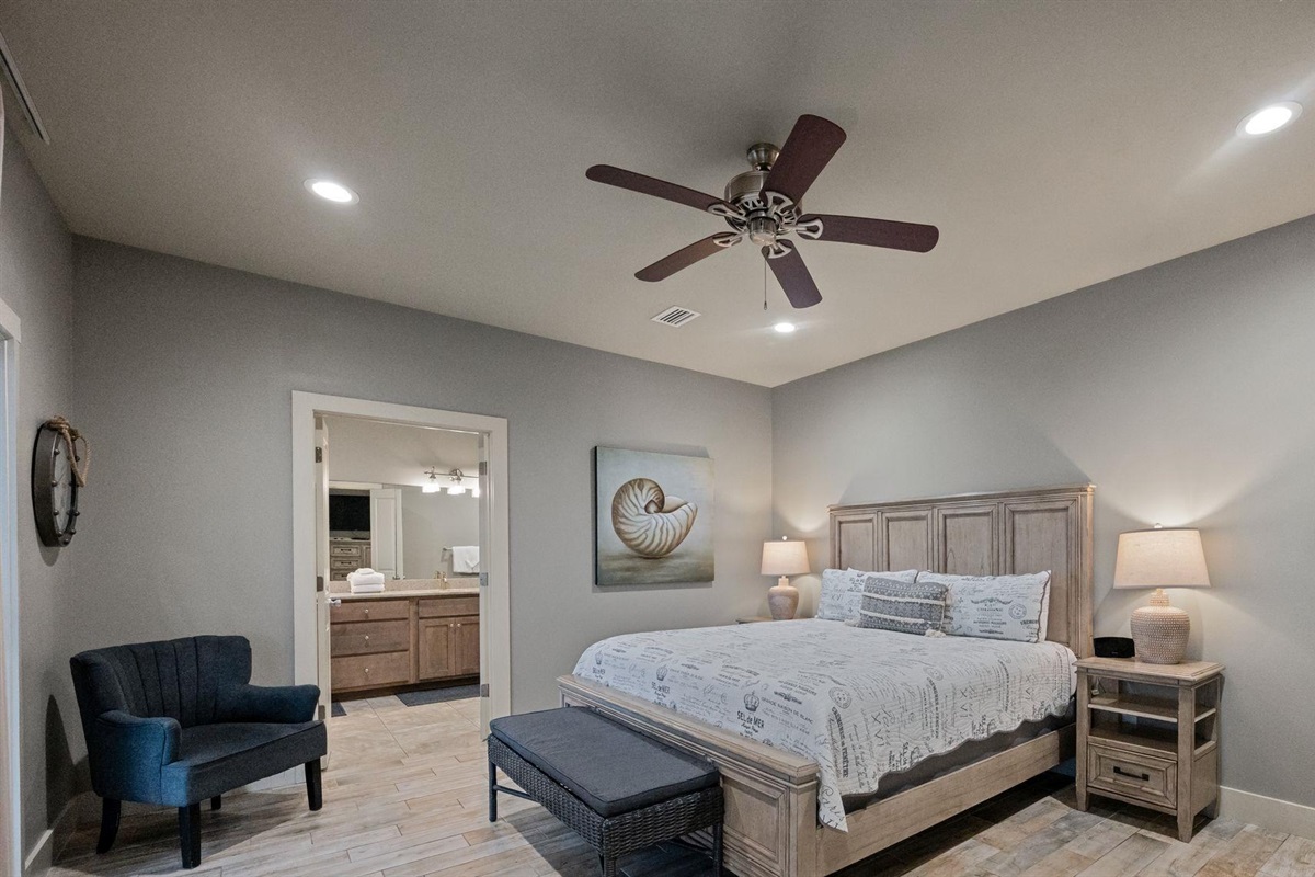 Bedroom with king bed, ceiling fan, TV and en-suite bathroom 