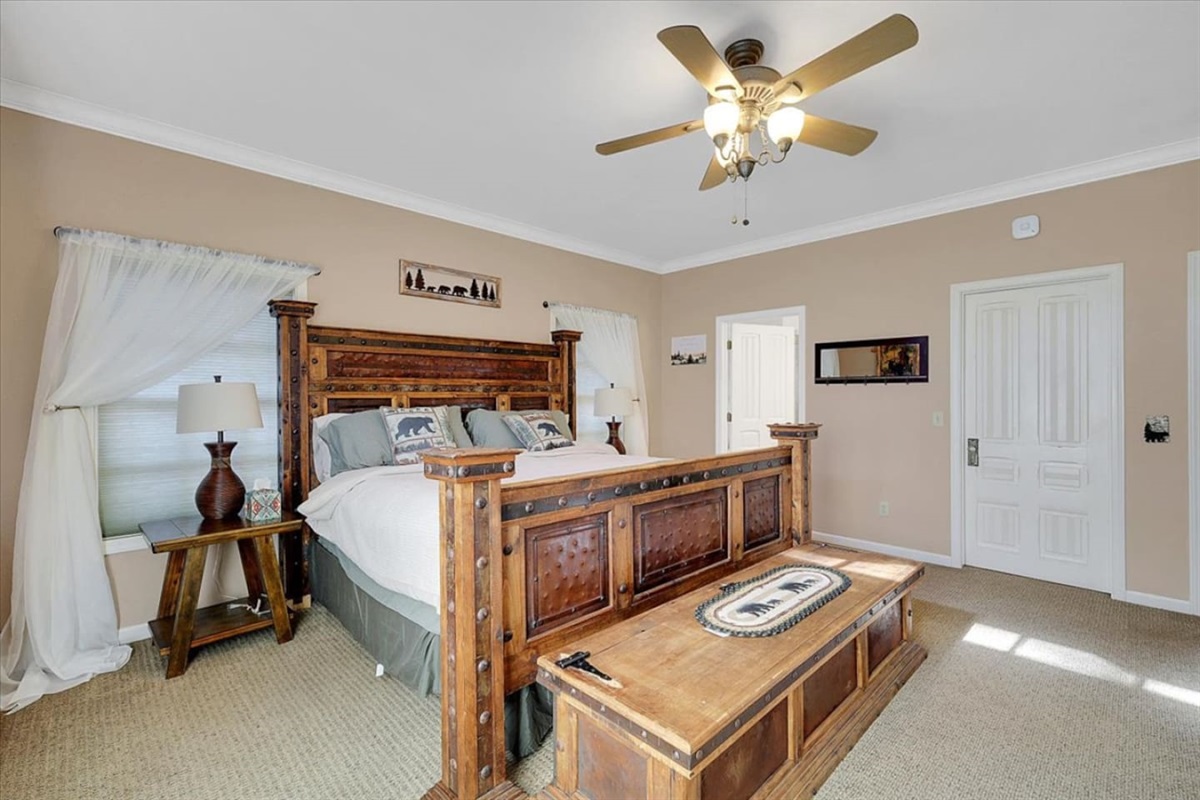 King bedroom with rustic wood furniture, bedside lamps, and a simple place to rest.
