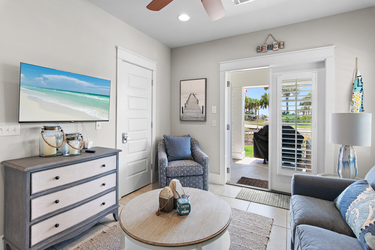 Cozy up in this bright coastal living space, with a comfortable seating area and easy access to the outdoor patio.