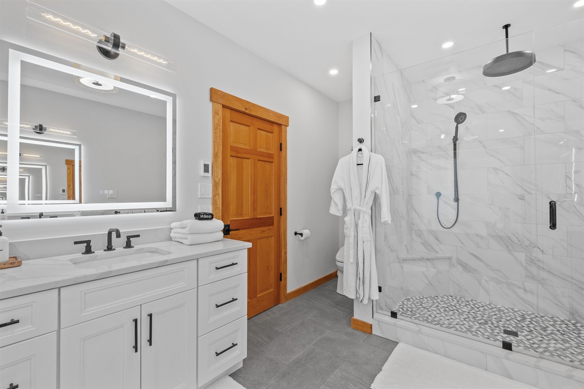 First floor master bathroom with dual vanities, heated floors, and walk in shower