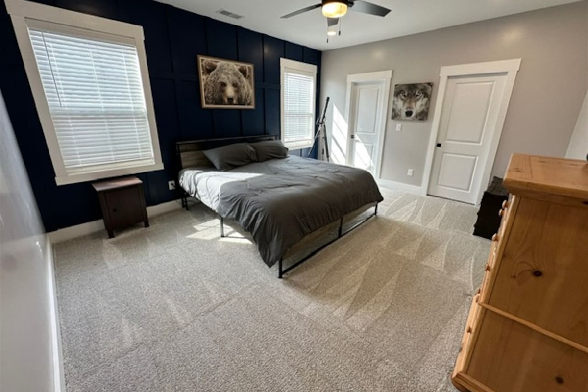 Large bedroom with private sink and shared access to private shower/toilet rooms with bedroom #2. Quaint under stair nook on opposite wall.