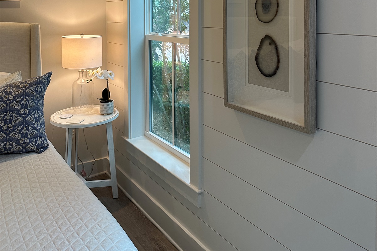 Spacious 1st floor king guest suite with soft lighting, artwork and natural light from window with blinds for privacy