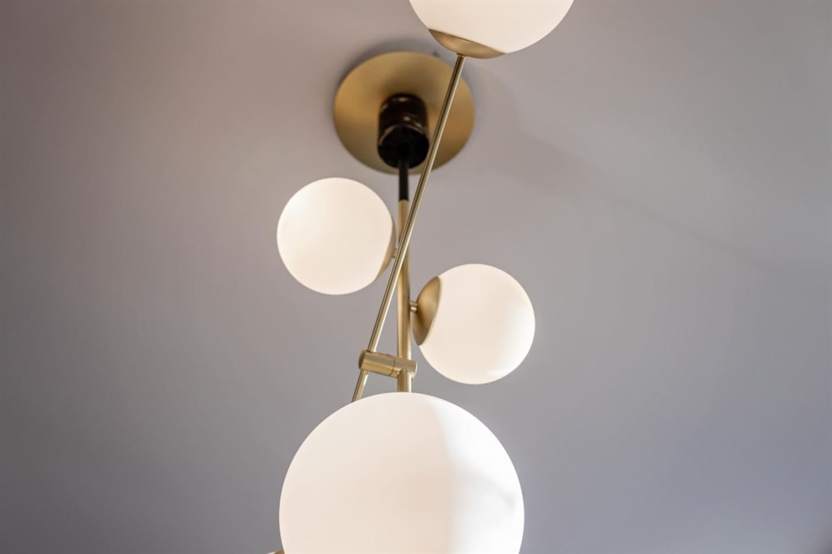 Modern chandelier with elegant globe lights, adding a touch of sophistication and warmth to your stay.
