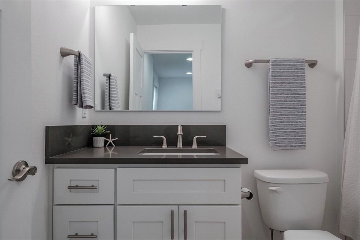 Coastal details offer a simple, refreshing atmosphere in the guest suite bathroom. 