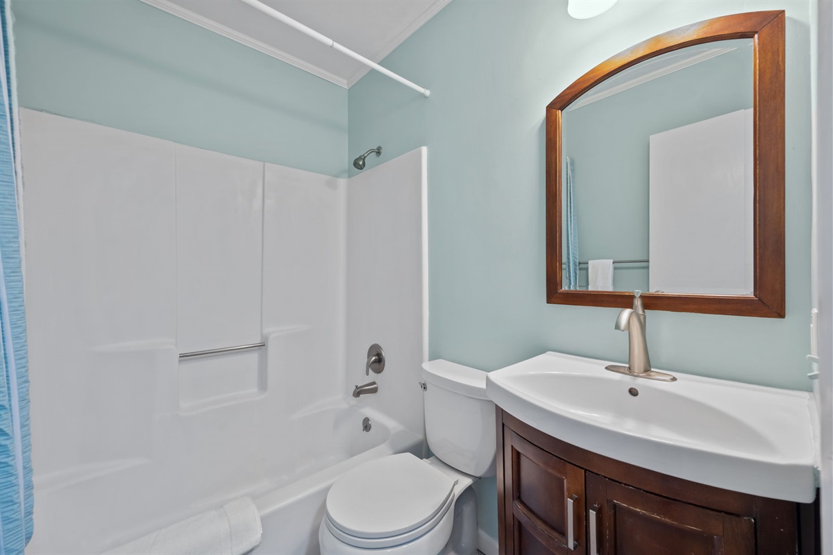 Fresh and bright bathroom with a clean vanity and tub shower combo