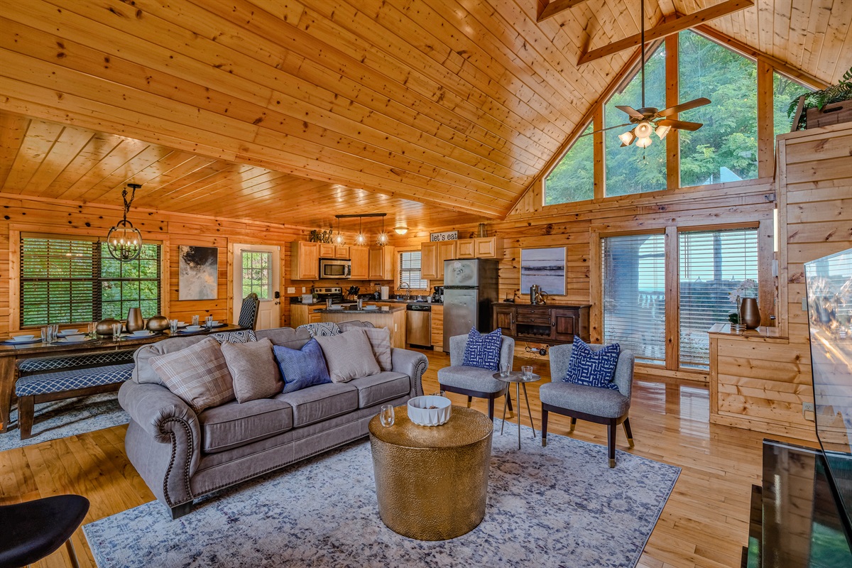 Cabin main level has open floor plan with kitchen, living and dining area. Vaulted ceilings with large windows allow for lots of sunlight and spectacular views