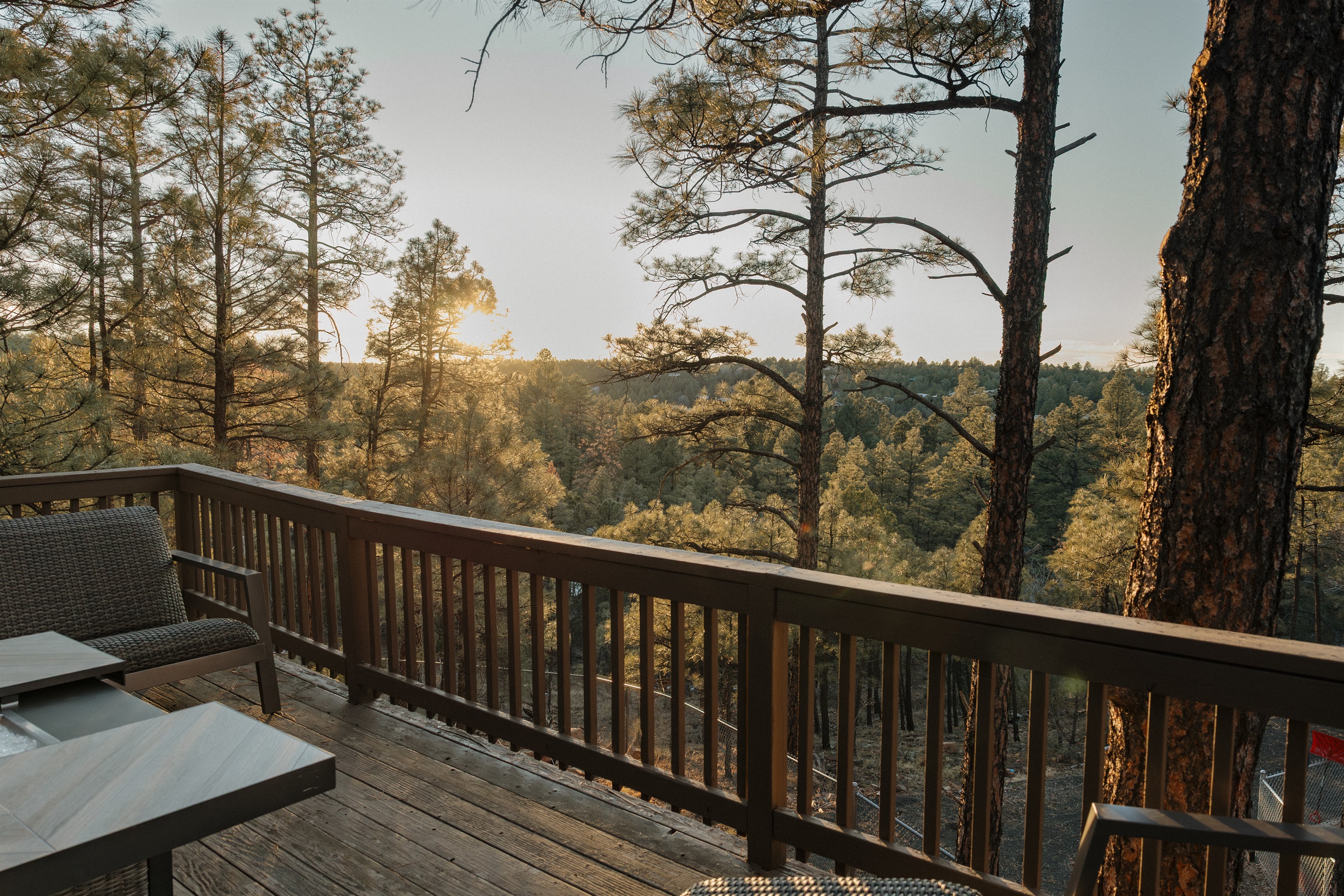 Golden hour views from the deck at Poppywood Pines showcase endless ponderosa pines and mountain vistas. This tranquil Show Low cabin offers the perfect spot for morning coffee or evening relaxation, surrounded by the natural beauty of the White Mountains.