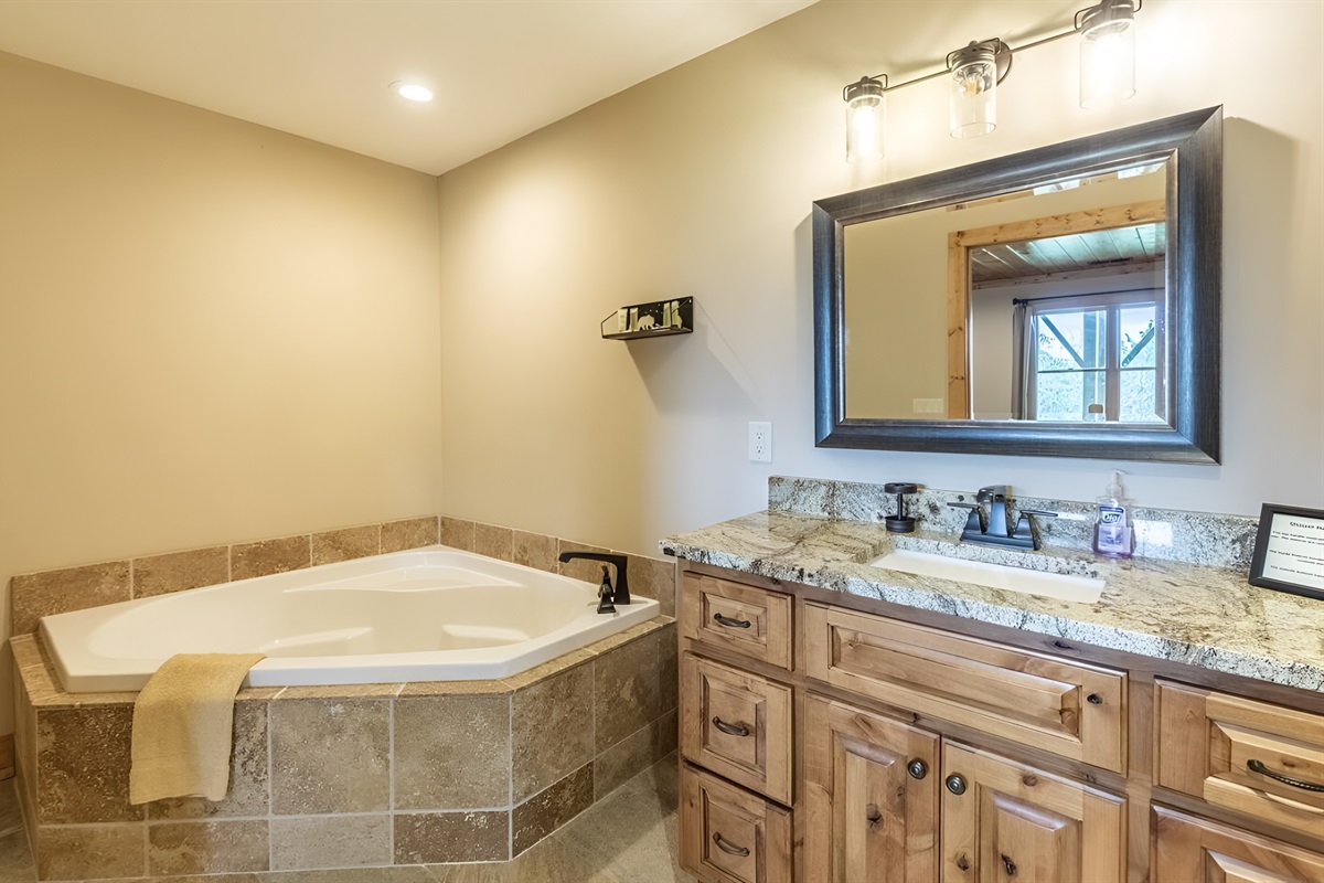 The upper level king bathroom has a large tub and sink for your stay.