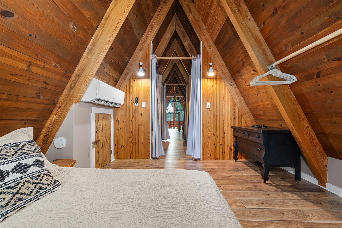 Open loft view — rustic wood beams and airy layout.