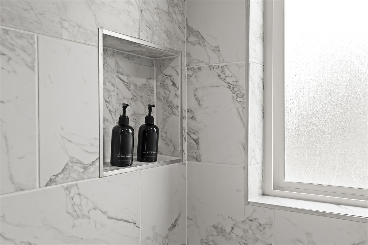 Modern bathroom with full-size tub, granite vanity, and bright lighting.