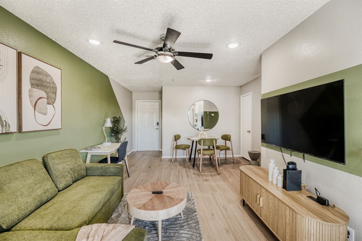 Modern living room with green accents, cozy seating, and a stylish open layout.