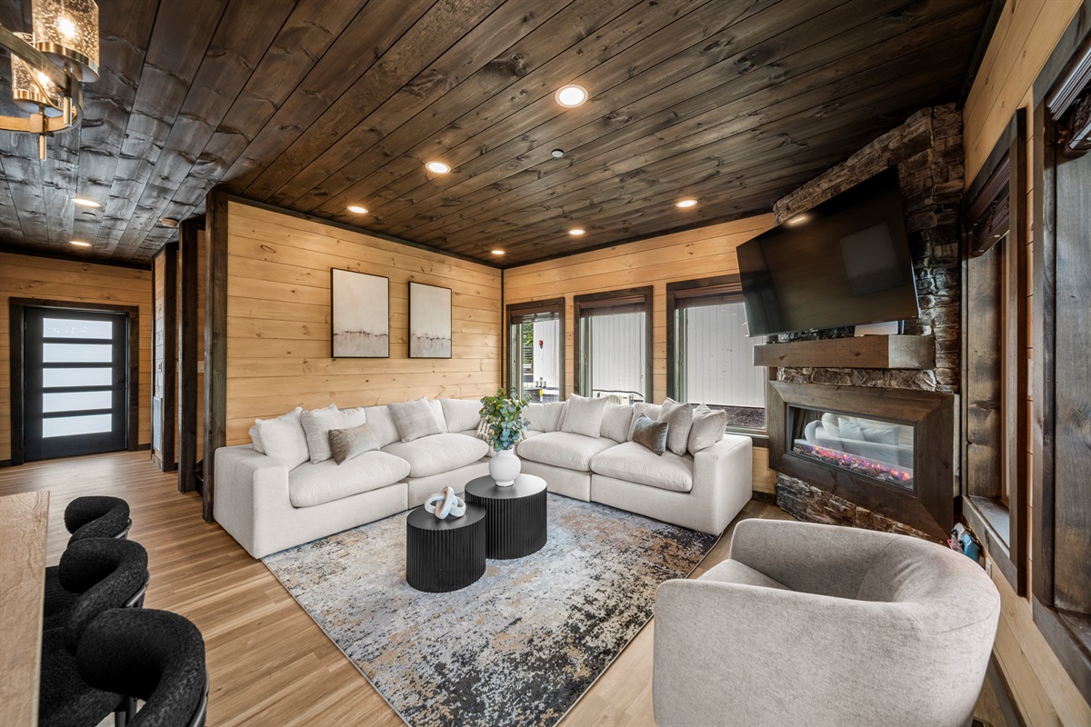 Modern living room with PS5, smart TV, and cozy seating