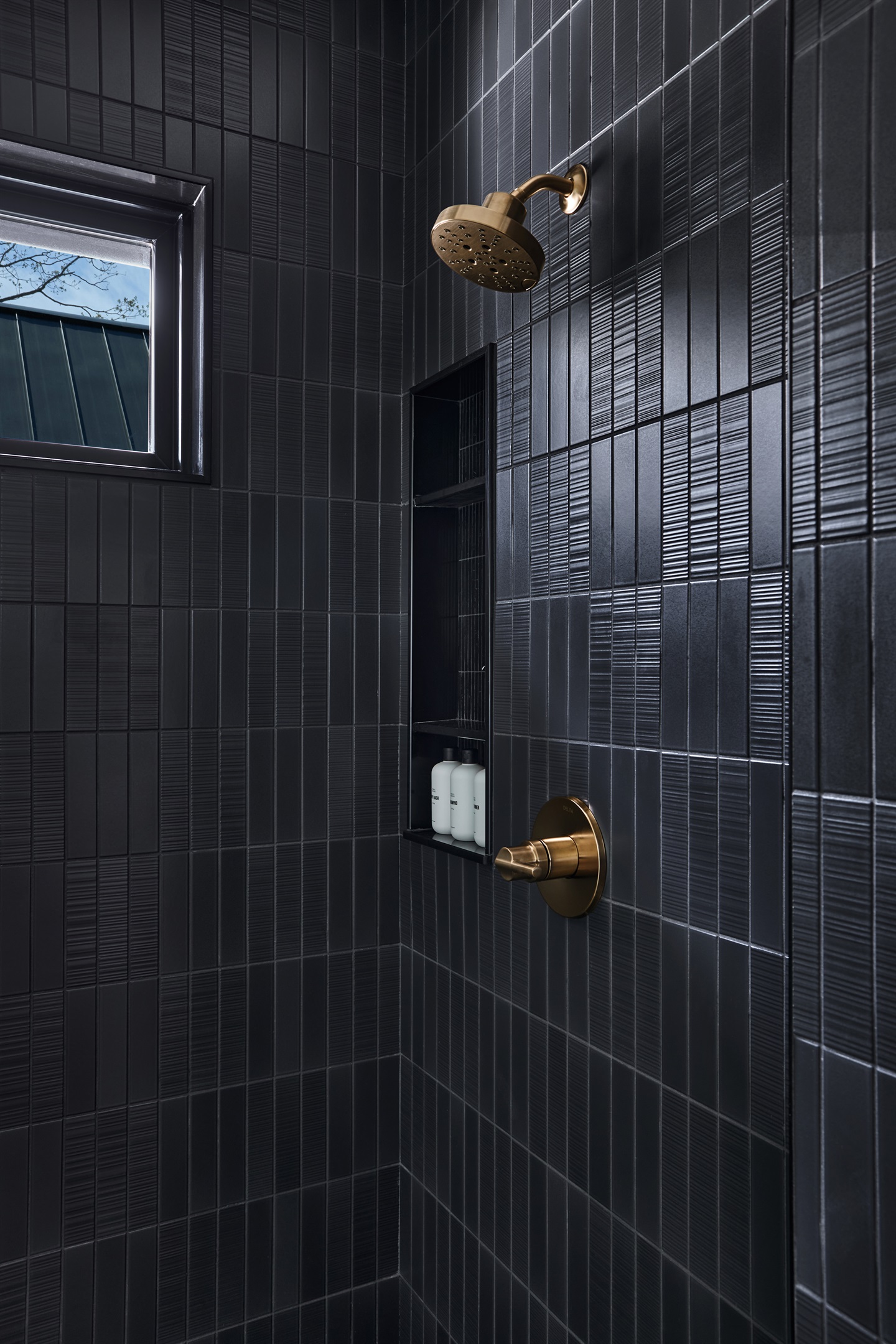 A bold, modern bathroom with striking geometric tile, built-in shelving, and natural light.