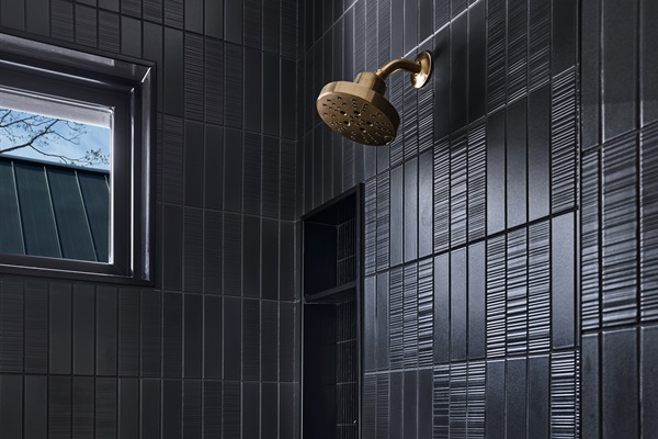 A bold, modern bathroom with striking geometric tile, built-in shelving, and natural light.