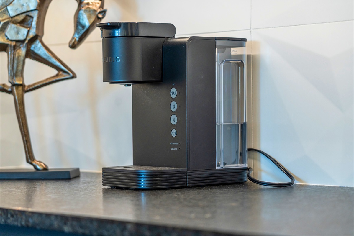 The streamlined coffee station is a delightful touch, offering a convenient spot to craft the perfect brew while maintaining the kitchen’s polished aesthetic.