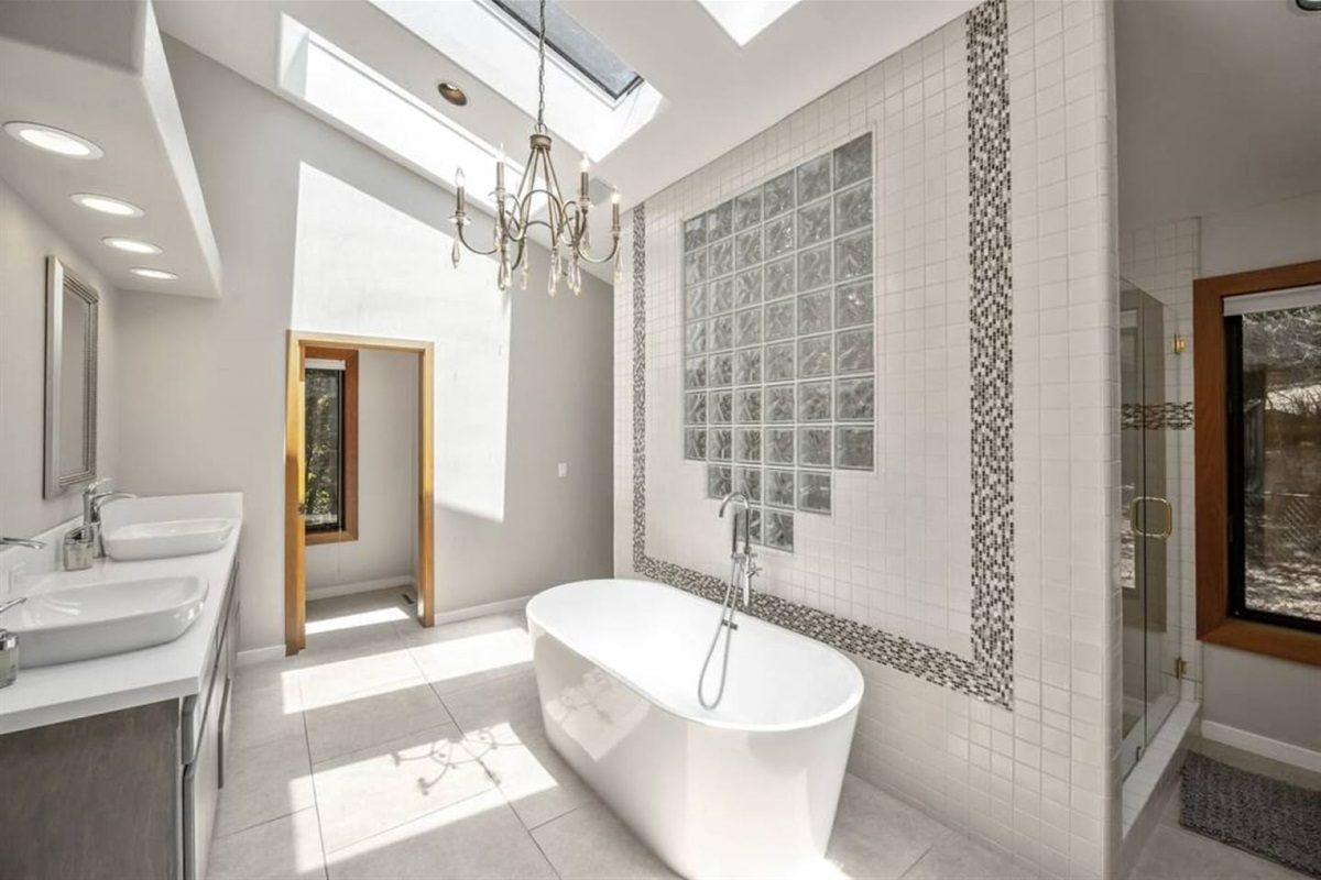 Ensuite bathroom attached to the primary bedroom. Soaking tub, two sinks, large shower with two shower heads, and two walk-in closets.