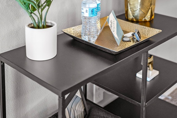 A warm welcome awaits! Enjoy complimentary bottled water, a sleek gold tray for keys and accessories, a modern lamp, and greenery that adds a fresh touch to your arrival.