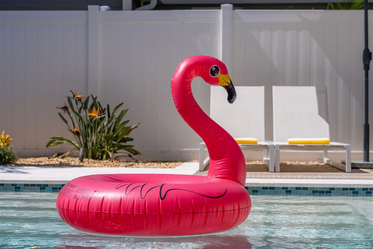 The pool’s clean lines and calming color palette are matched only by its playful flamingo float and inviting seating areas.