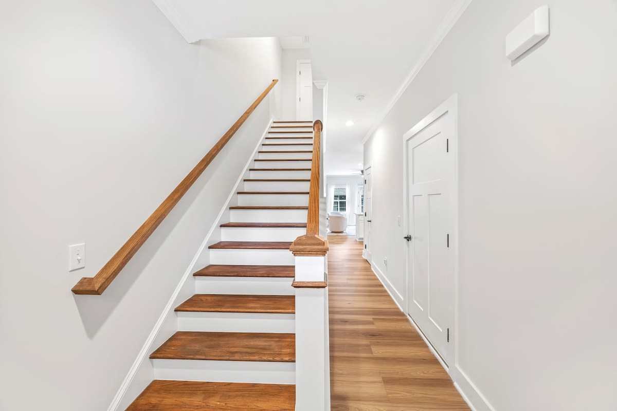 Polished wood stairs and crisp white trim lead you to the peaceful upper-level bedrooms.

