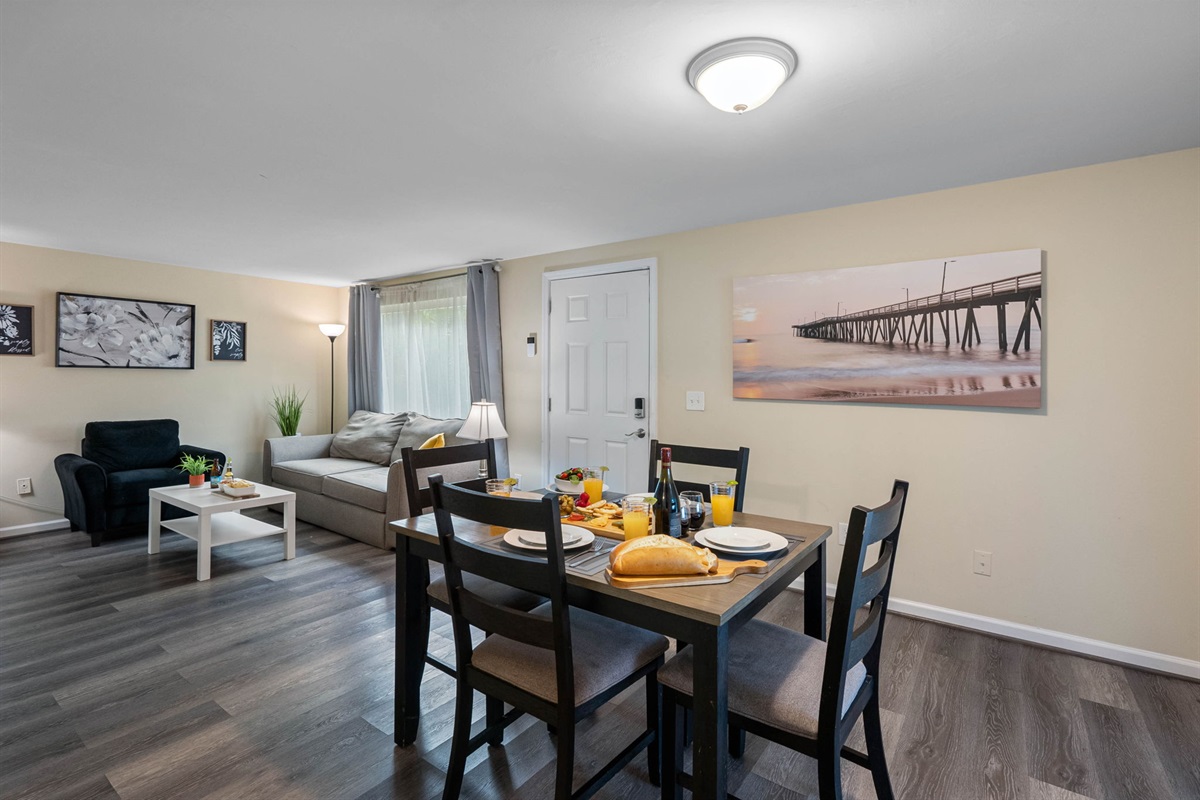 Featuring a solid wood dining table with a natural finish and four cushioned chairs in a sleek dark frame.