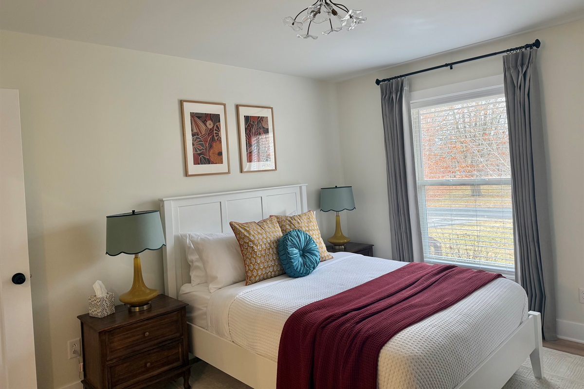 Comfortable bedroom featuring a plush queen bed with professionally cleaned linens, blackout curtains, and a noise machine for a restful night’s sleep. Includes a convenient attached ¾ bath for added privacy and ease