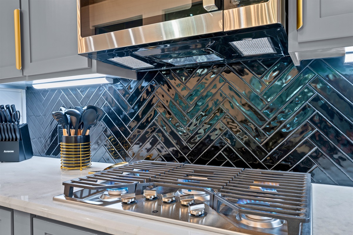 The gas cooktop and stylish backsplash create a sleek cooking space where preparing meals becomes part of the fun.