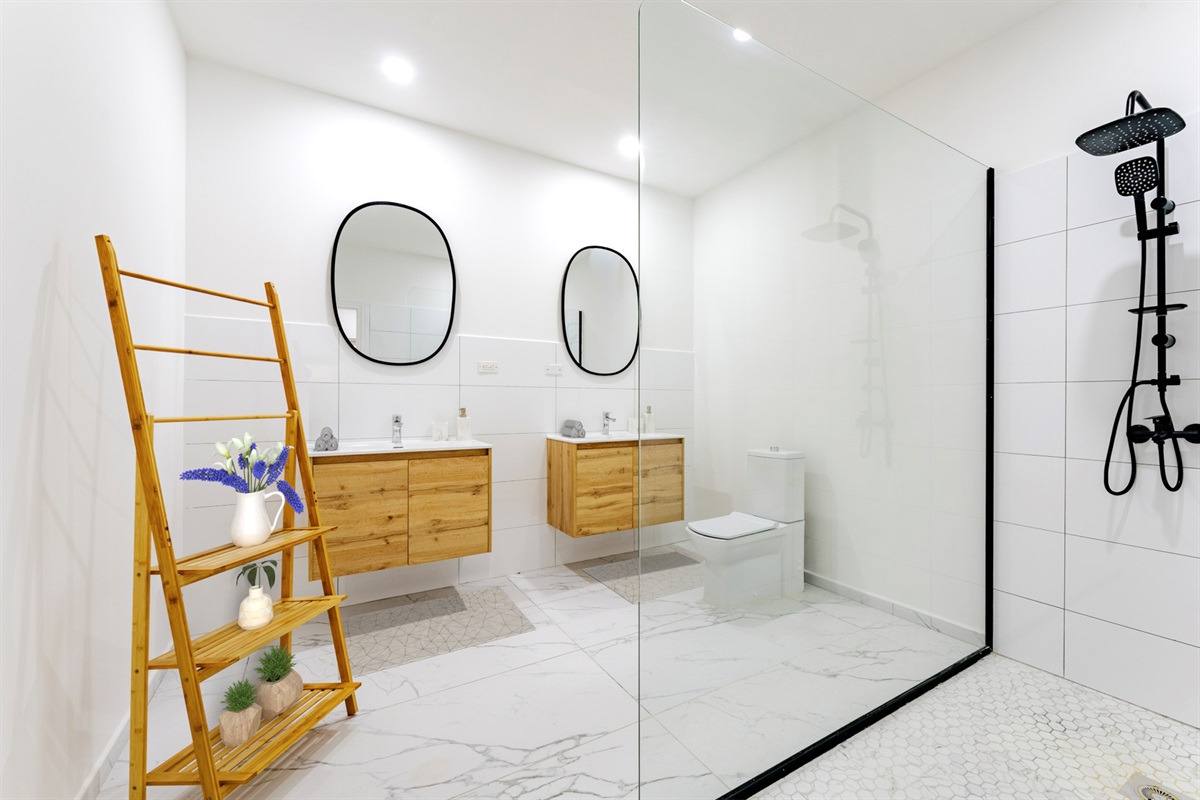 Bathroom décor with towel ladder and greenery adding a spa-like touch.