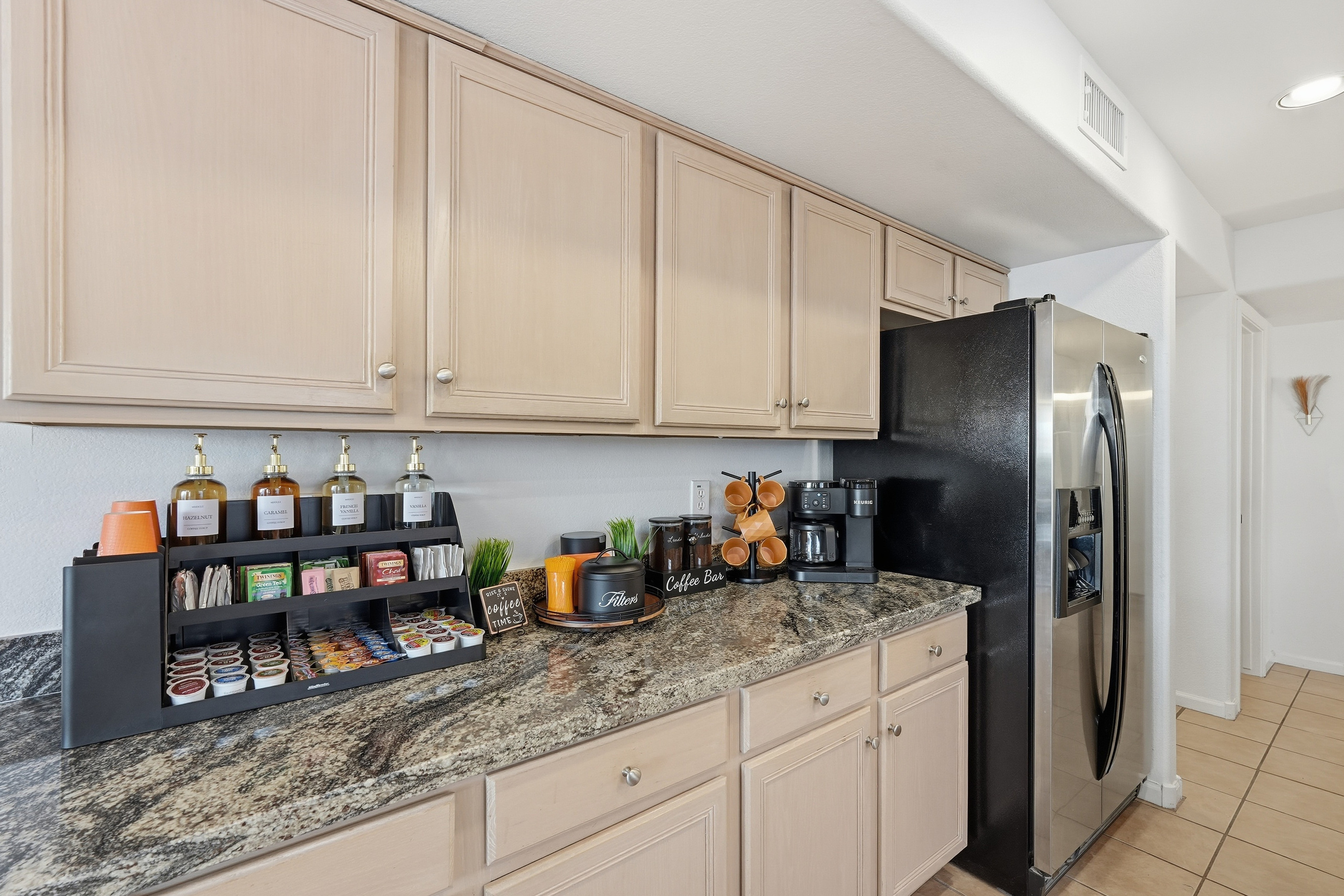 Coffee corner with drip coffee maker, pods, syrups, and counter space for easy mornings during your stay.