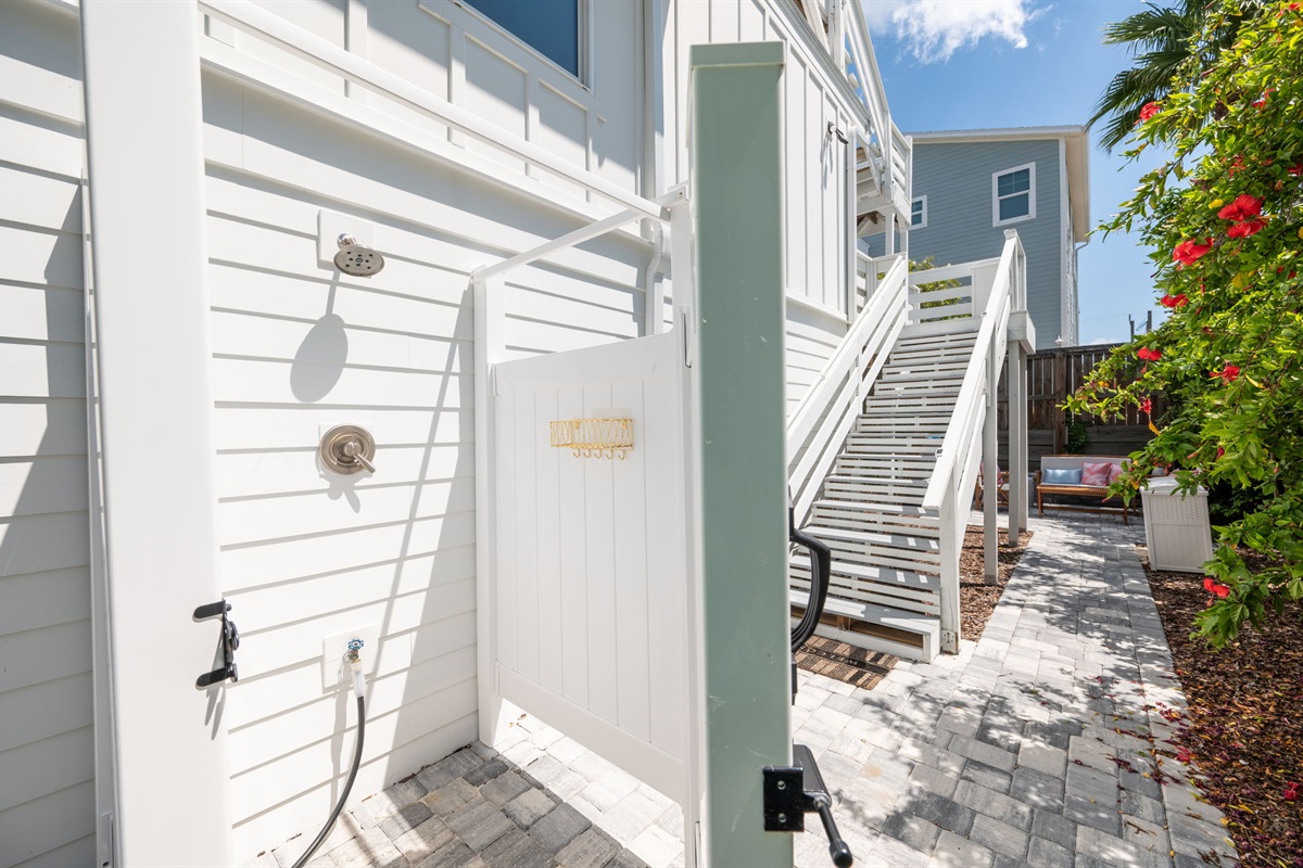 Here’s the outdoor shower, perfect for rinsing off after a day at the beach. Beneath the stairs, leading from the deck to the patio, you’ll find a collection of beach gear—chairs and a wagon—for our guests to use during their stay!
